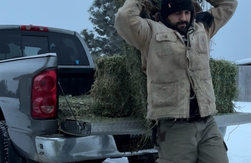 egistered Dietitian Franco Lopez carrying hay on his farm, illustrating the connection between strength, muscle, and metabolic health.